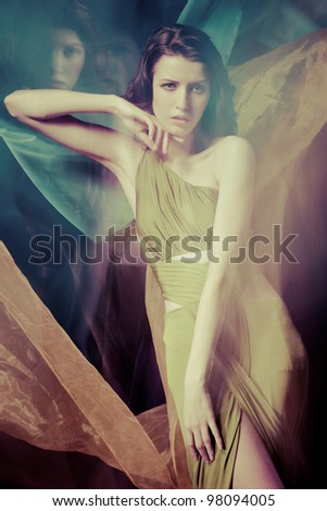 Fashion portrait of brunette lady in long dress shot in mixed light technique