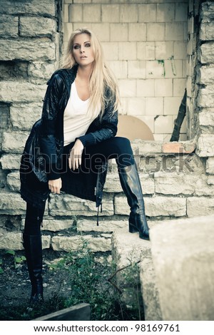Young woman posing in ruins of old factory