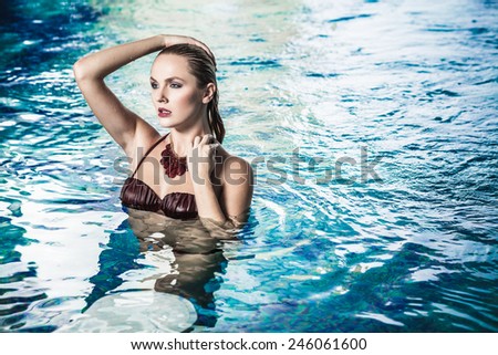 Young lady in bikini having a good time in swimming pool in spa