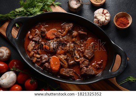Beef Bourguignon in a pan. Stew with red wine ,carrots, onions, garlic, a bouquet garni, and garnished with pearl onions, mushrooms and bacon. French cuisine- regional recipe from Burgundy