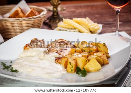 Grilled chicken breast with potato and cheese sauce