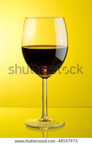 glass of red wine in yellow background