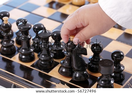 Childre hand with chess, isolated in white