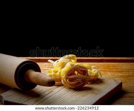 Fresh homemade tagliatelle with rolling pin on a table