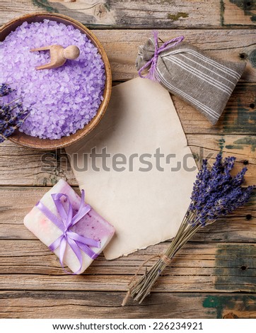 Lavender flower, soap, salt, sachet and blank paper on a wooden background