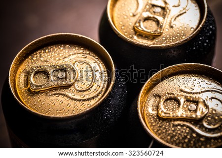 Top part of beer cans with water drops