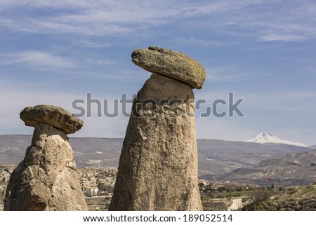Fairy chimneys in Cappadocia, Turkey, with snowy mountain in the background.