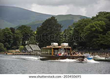 KESWICK, ENGLAND - JUNE 13: Group of tourists at Lake Derwentwater in Keswick, England on June 13, 2013. Lake Derwentwater is part of the famous Lake District in England.