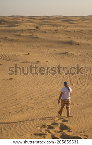 Dubai, UAE - November 1: Man walking in the desert heat near Dubai, UAE on November 1, 2013.