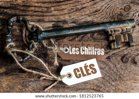 an old rusty key on a ribbed wooden table and  labels with the french text 'les chiffres clés' means The key figures Photo stock © 