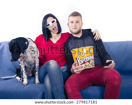 Couple with dog on the couch watching TV