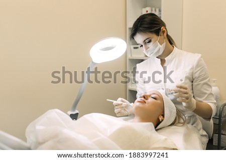 beautician applies cosmetic product to patient woman with brush Foto d'archivio © 