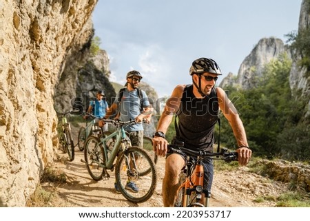 Similar – Image, Stock Photo Young man riding ebike in the park