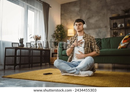 Similar – Image, Stock Photo A man with headphones pulls on his tongue with pliers