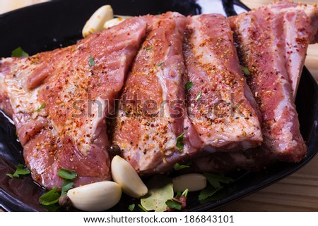 Fresh pork ribs, meat marinated and prepared for roast with garlic parsley allspice