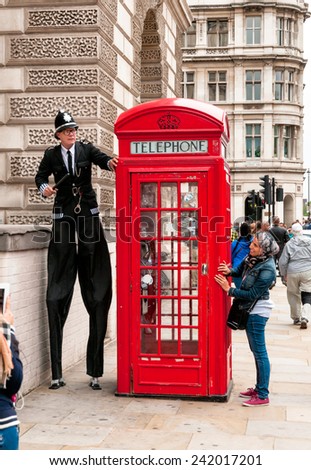 LONDON, ENGLAND - SEPTEMBER 15, 2013: Street artist perform in front of a red phone booth