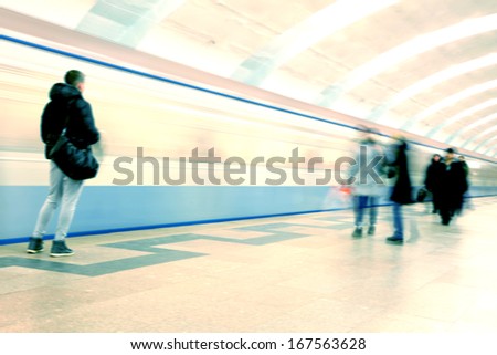 Train in motion blur and blurred people at subway station.