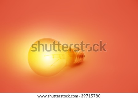 Glowing light bulb on red.