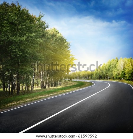 Empty curved road,blue sky and sun.