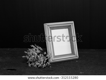 Frame on a wooden table on a black background, Still Life.