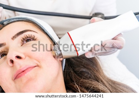 Radio frequency microneedling machine handpiece on the cheek of a woman's face during a beauty skin tightening treatment. Stok fotoğraf © 
