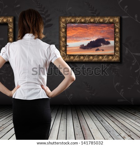 Woman standing in the gallery and watching art