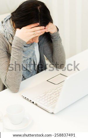 Stressed business woman getting headache with laptop