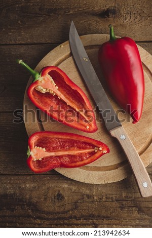 Still life of sweet red peppers on a wooden chopping board