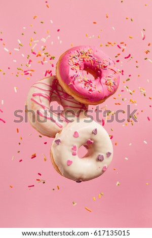 Similar – Foto Bild Mehrfarbige Donuts mit Zuckerstreuseln bestreut fliegen auf einem gelben Hintergrund