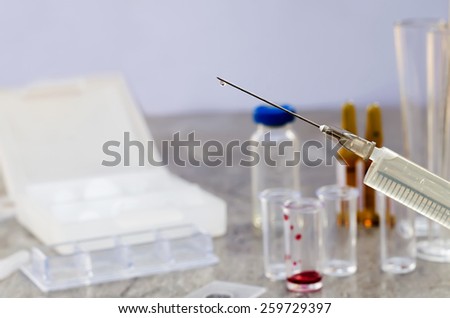 Syringe and vaccine front of a laboratory scene