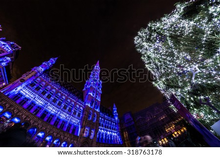 Christmas tree in the middle of blue-illuminated Grand Place, the focal point of Brussels, Belgium