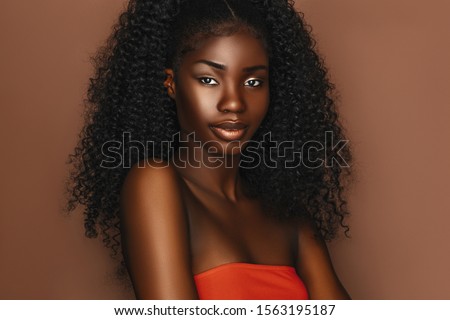 Photo of African beautiful woman portrait. Brunette curly haired young model with dark skin and perfect smile