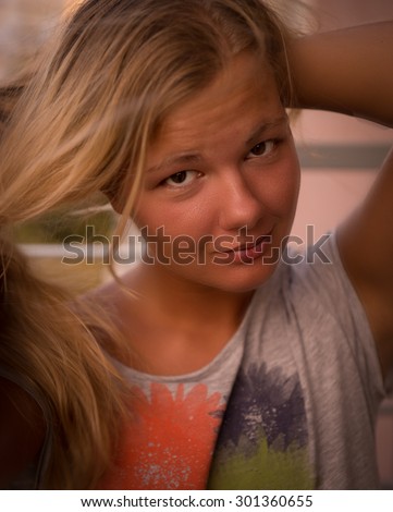 Smiling blonde with brown eyes at sunset straightens hair