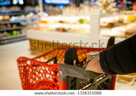 Blurred brightly background of the supermarket. A man make shopping. Male hands with basket close-up. Cashier, gueues at the store. Sale time concept. Photo stock © 