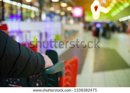 Blurred brightly background of the supermarket. A man make shopping. Male hands with cart close-up at the store. Sale time concept. Photo stock © 