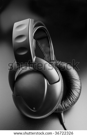 Black music - closed black earphones on black background