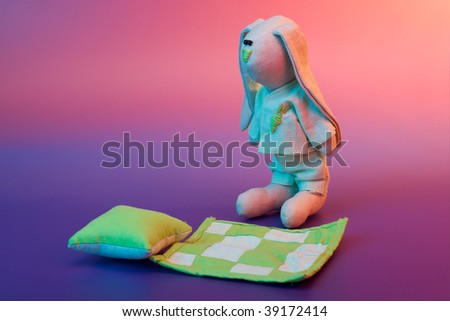 Go to sleep - sleepy hare toy on color background