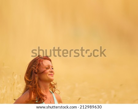 attractive woman in wheat field with warm light filter during sunrise or sunset