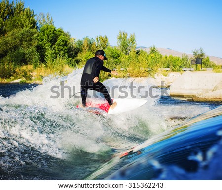 male surfer cutting on his board at the top of a wave with a toned instagram filter