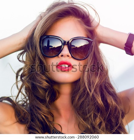 Close up fashion  summer  portrait of stylish  sexy  woman with perfect  tanned fit body   wearing trendy sunglasses drinking cocktail and  enjoying  pool party on luxury villa.