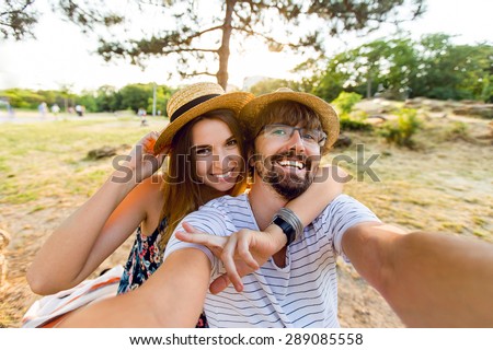 Happy lovers, attractive woman and man walking in park  enjoying romance.   funny couple making selfie, smiling and have fun together.