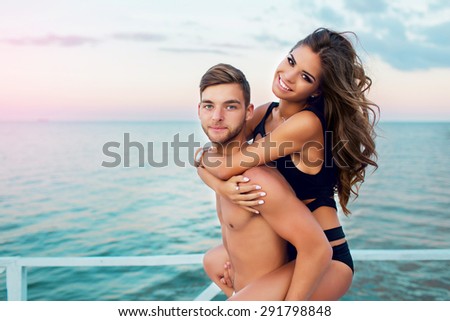 Happy couple in live have fun and relaxing on summer vacation sea background. Attractive lovers posing on the evening beach.