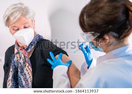 An elderly woman receiving the injection of the coronavirus vaccine by a doctor to receive the antibodies, immunize the population. side effects, risk people, antibodies, new normal, covid-19.