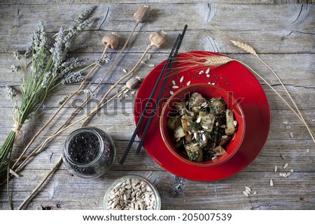 roasted japanese turnips with leaves and seeds on red bowl on rustic background