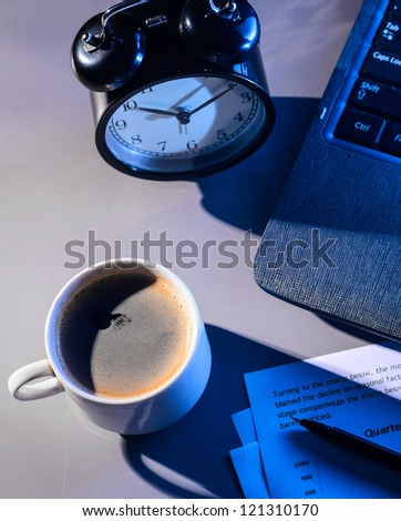 working at night, laptop with documents and cup of coffee on table
