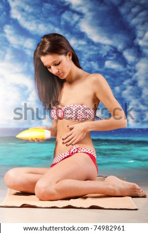 woman is applying sun block cream at beach, dramatic skies