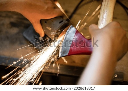 Similar – Image, Stock Photo Worker sharpening axe with electric grinder