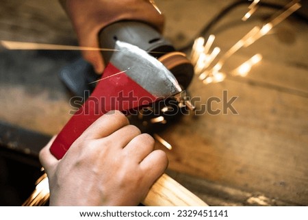 Image, Stock Photo Worker sharpening axe with electric grinder