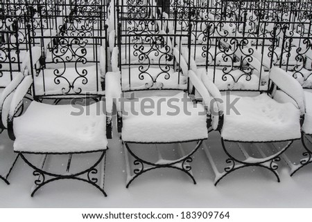 Metal chairs covered in thick snow