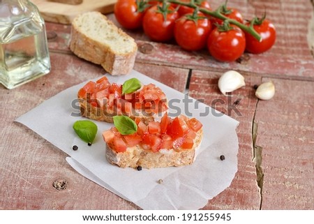 Tomato bruschetta - bread toast with tomatoes, garlic and pepper on wooden background. Selective focus